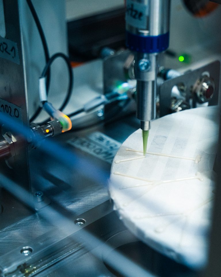 Automatisierte Klebeanlage mit Präzisionsdüse, die Klebstoff aufträgt.